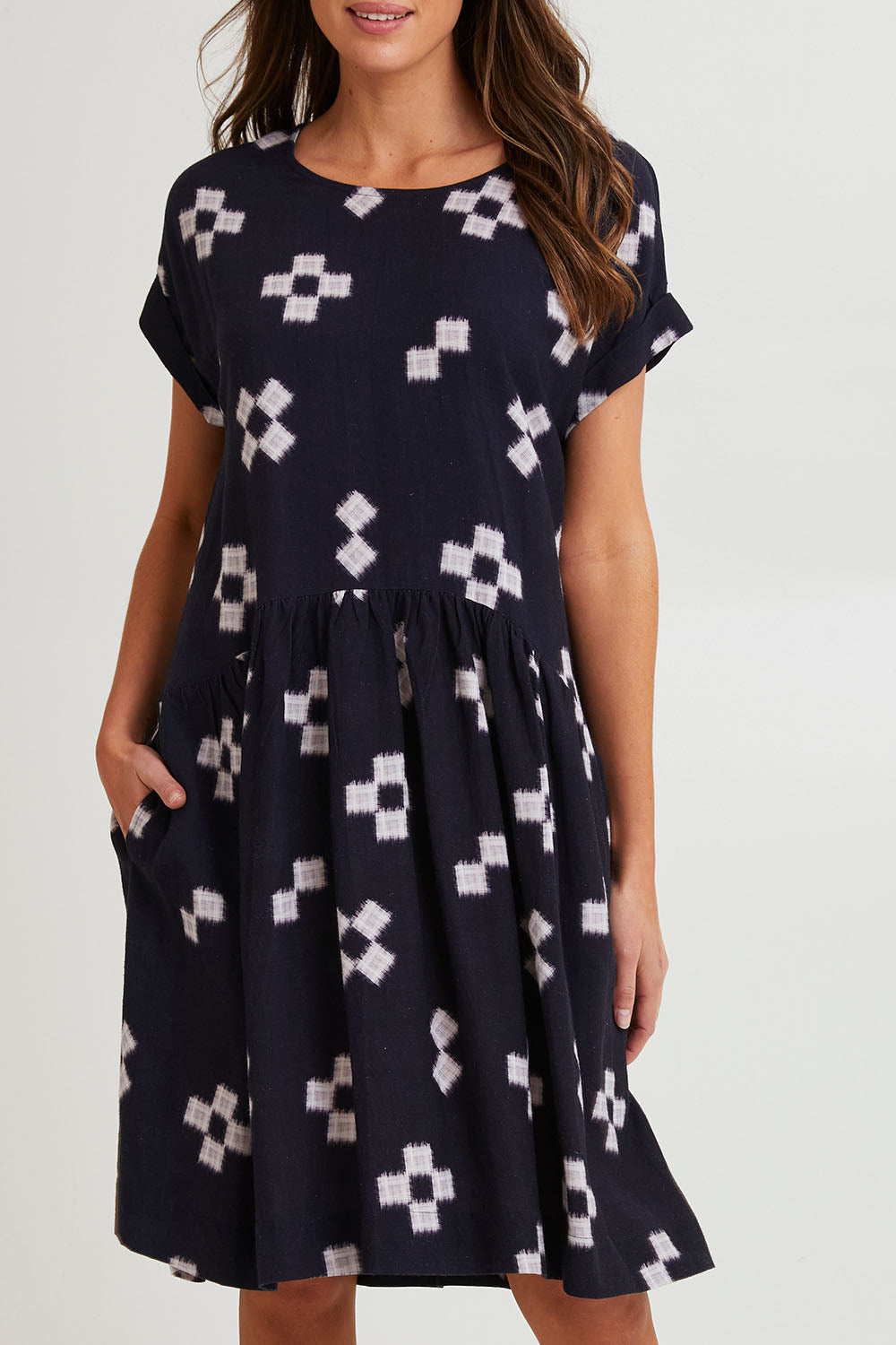 Model Madeline wearing size 10 of the Positano Linen Blend Dress in colour Navyprint (Blue), from the front, cropped image