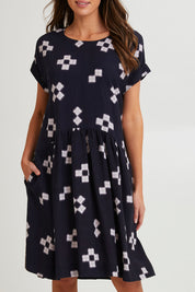 Model Madeline wearing size 10 of the Positano Linen Blend Dress in colour Navyprint (Blue), from the front, cropped image