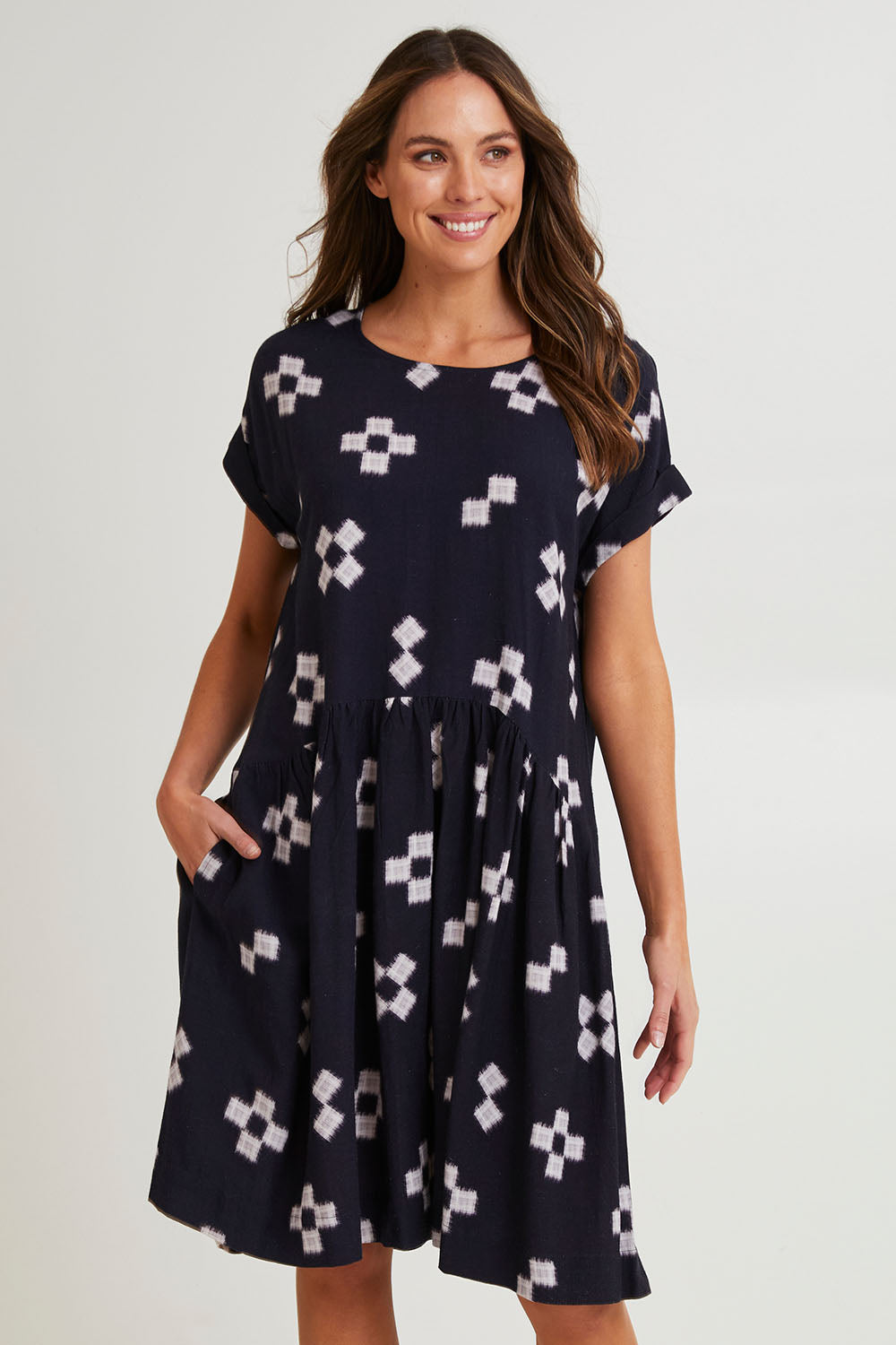 Model Madeline wearing size 10 of the Positano Linen Blend Dress in colour Navyprint (Blue), from the front, cropped image