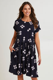 Model Madeline wearing size 10 of the Positano Linen Blend Dress in colour Navyprint (Blue), from the front, cropped image