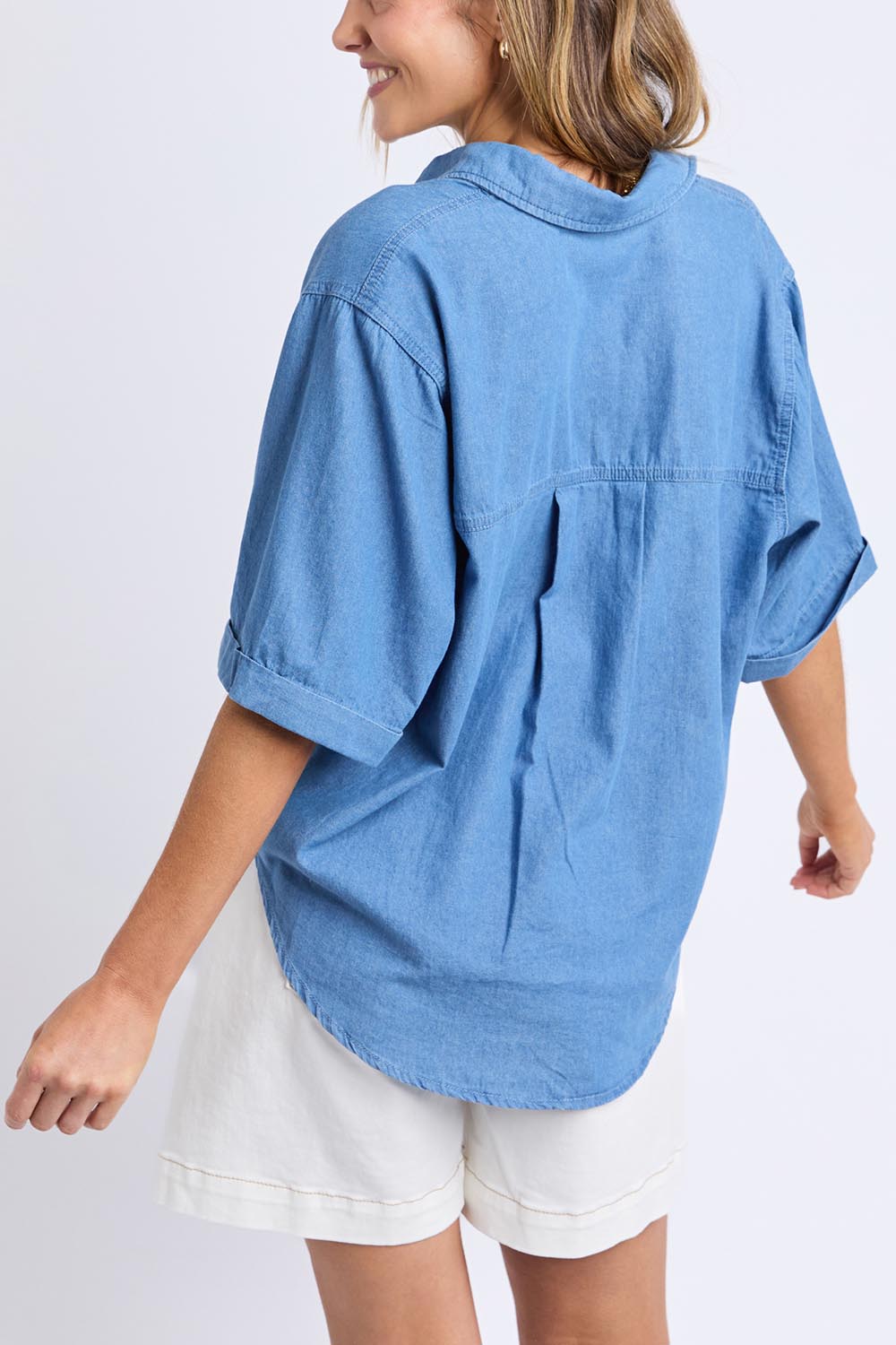 A model wearing the Blissful Chambray Ss Shirt in colour Midblue (Blue), from the back