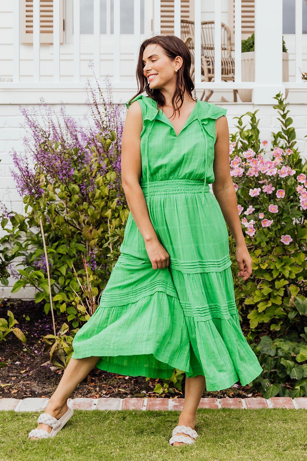 A model wearing the Isabella Cotton Blend Dress in colour Greenbriar (Green), from the front, showing the whole outfit