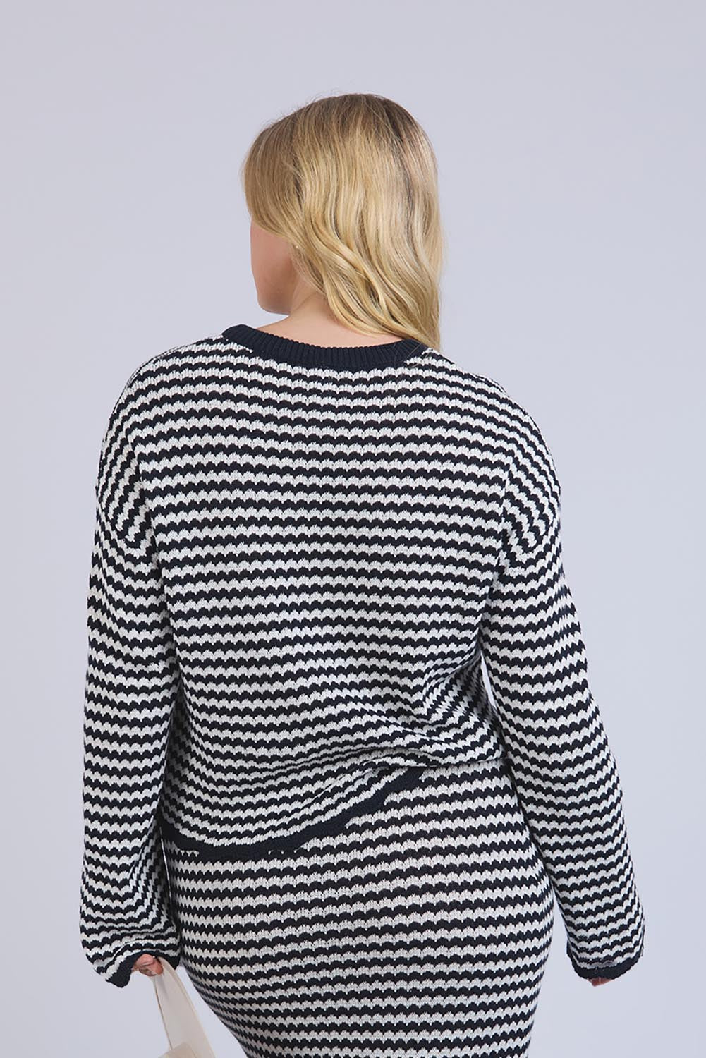A model wearing the Rosie Stripe Cotton Knit Top in colour Navywhite, from the back