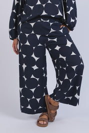 A model wearing the Demi Spot Lyocell Linen Pant in colour Spotprint (Blue), from the front, cropped image