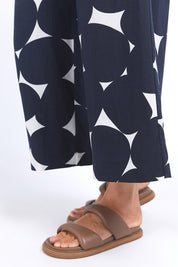A model wearing the Demi Spot Lyocell Linen Pant in colour Spotprint (Blue), from the front, cropped image