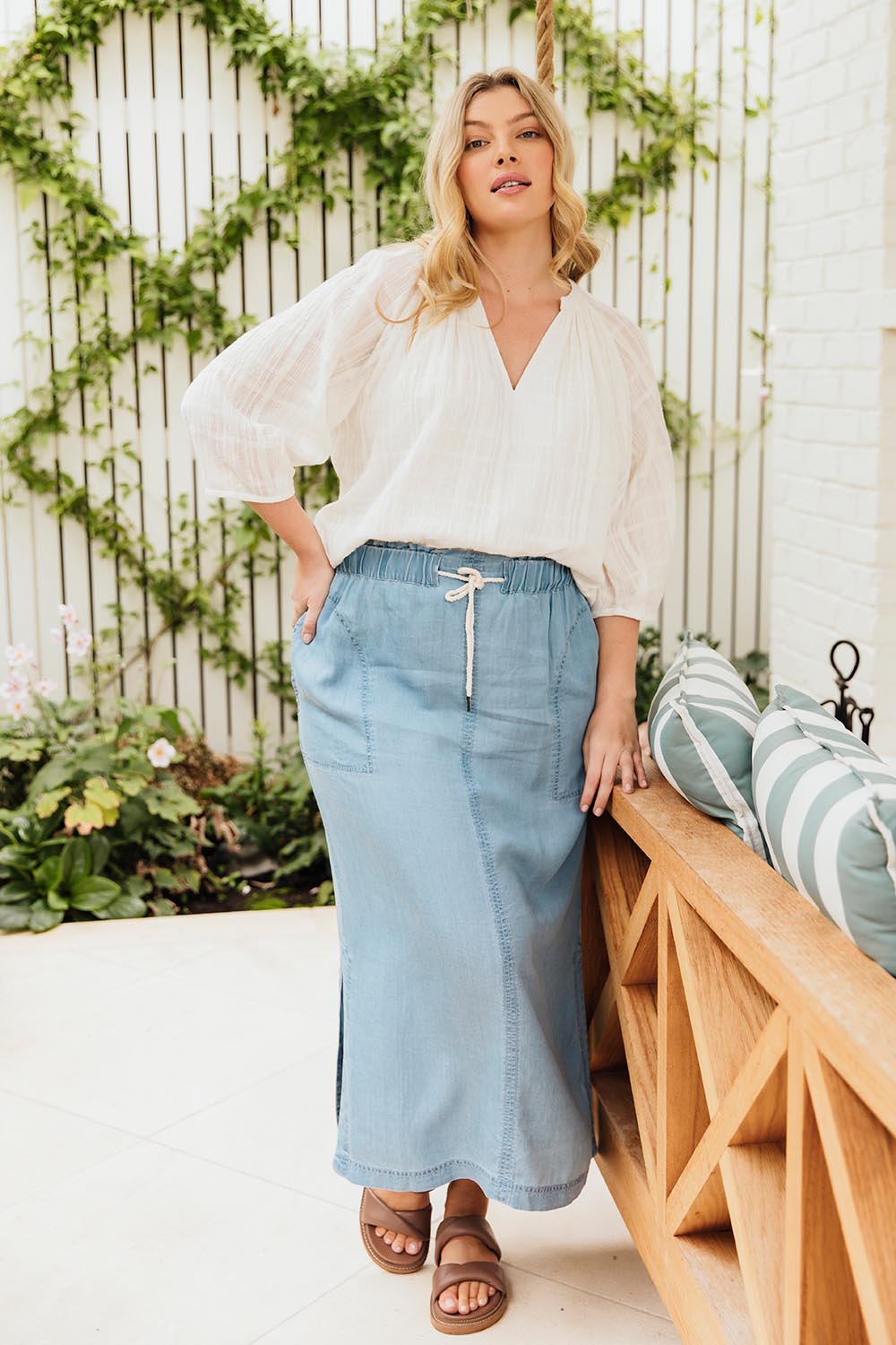 A model wearing the Penny Chambray Utility Skirt in colour Midblue (Blue), from the front, showing the whole outfit