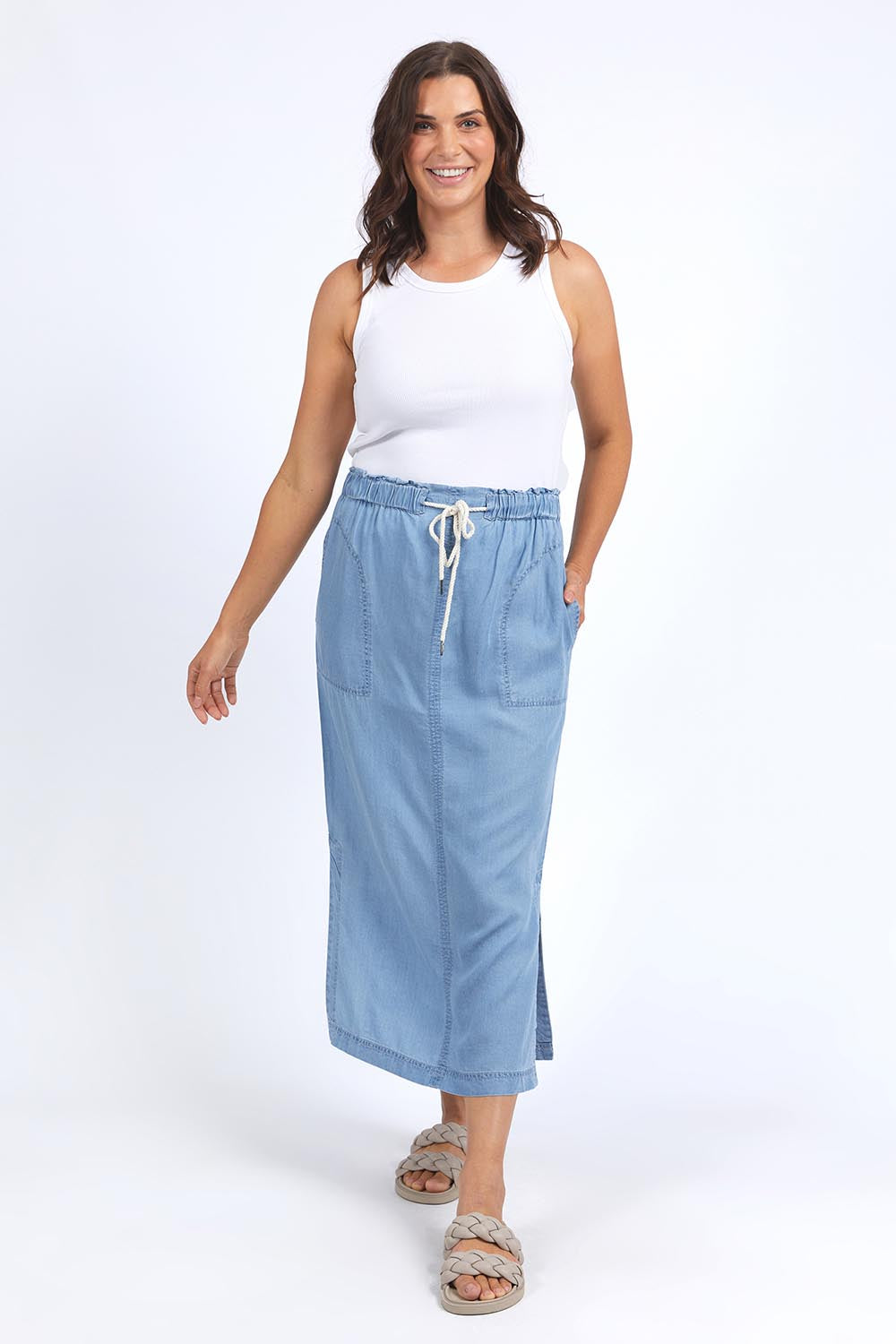 A model wearing the Penny Chambray Utility Skirt in colour Midblue (Blue), from the front, showing the whole outfit