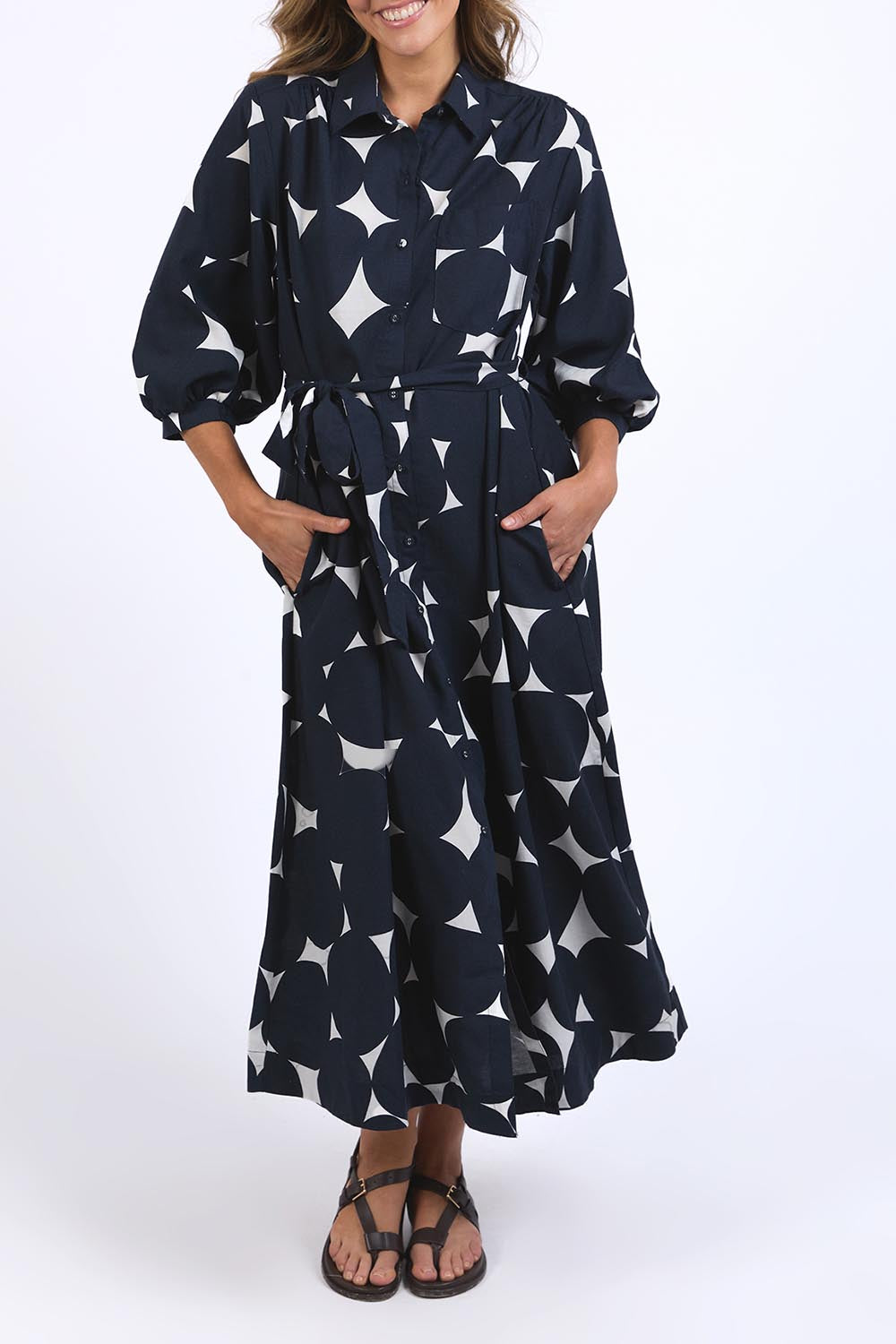 A model wearing the Demi Spot Dress in colour Spot (Blue), from the front, cropped image