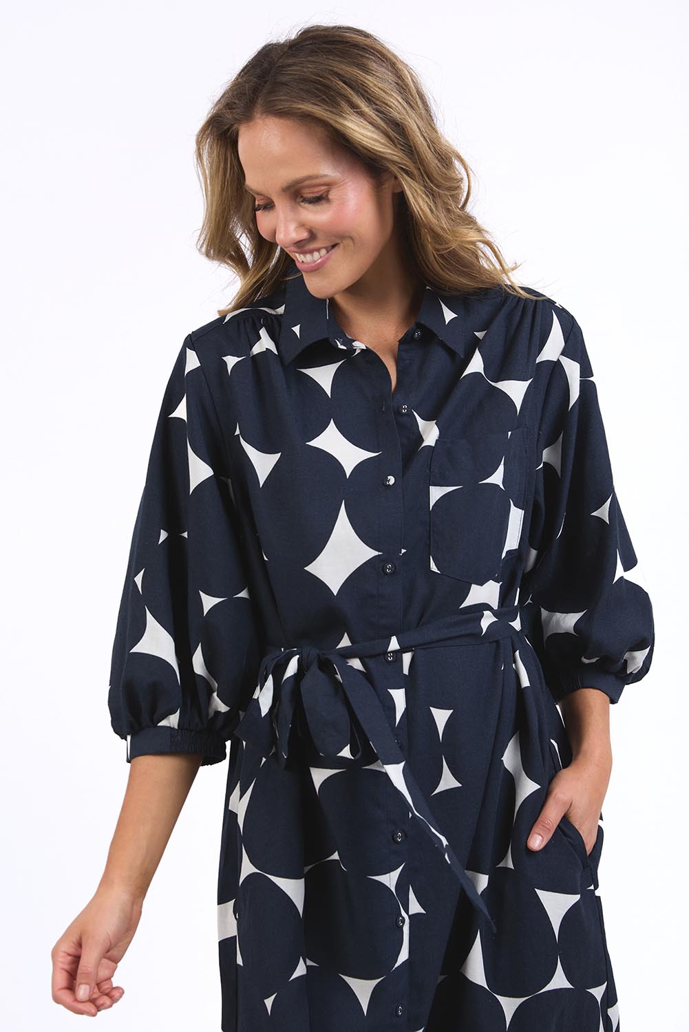 A model wearing the Demi Spot Dress in colour Spot (Blue), from the front, cropped image