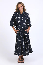 A model wearing the Demi Spot Dress in colour Spot (Blue), from the front, showing the whole outfit