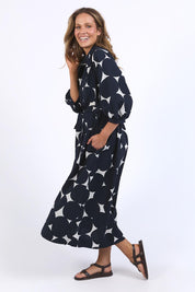 A model wearing the Demi Spot Dress in colour Spot (Blue), from the front, showing the whole outfit