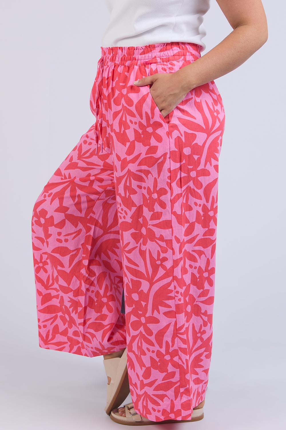 A model wearing the Sunset Hour Linen Blend Pant in colour Sunset (Pink), from the front, cropped image