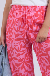 A model wearing the Sunset Hour Linen Blend Pant in colour Sunset (Pink), from the front, cropped image