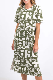 A model wearing the Postcard Tee Dress Clover in colour Clover (Green), from the front, cropped image