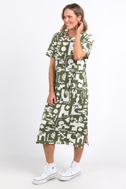 A model wearing the Postcard Tee Dress Clover in colour Clover (Green), from the front, showing the whole outfit