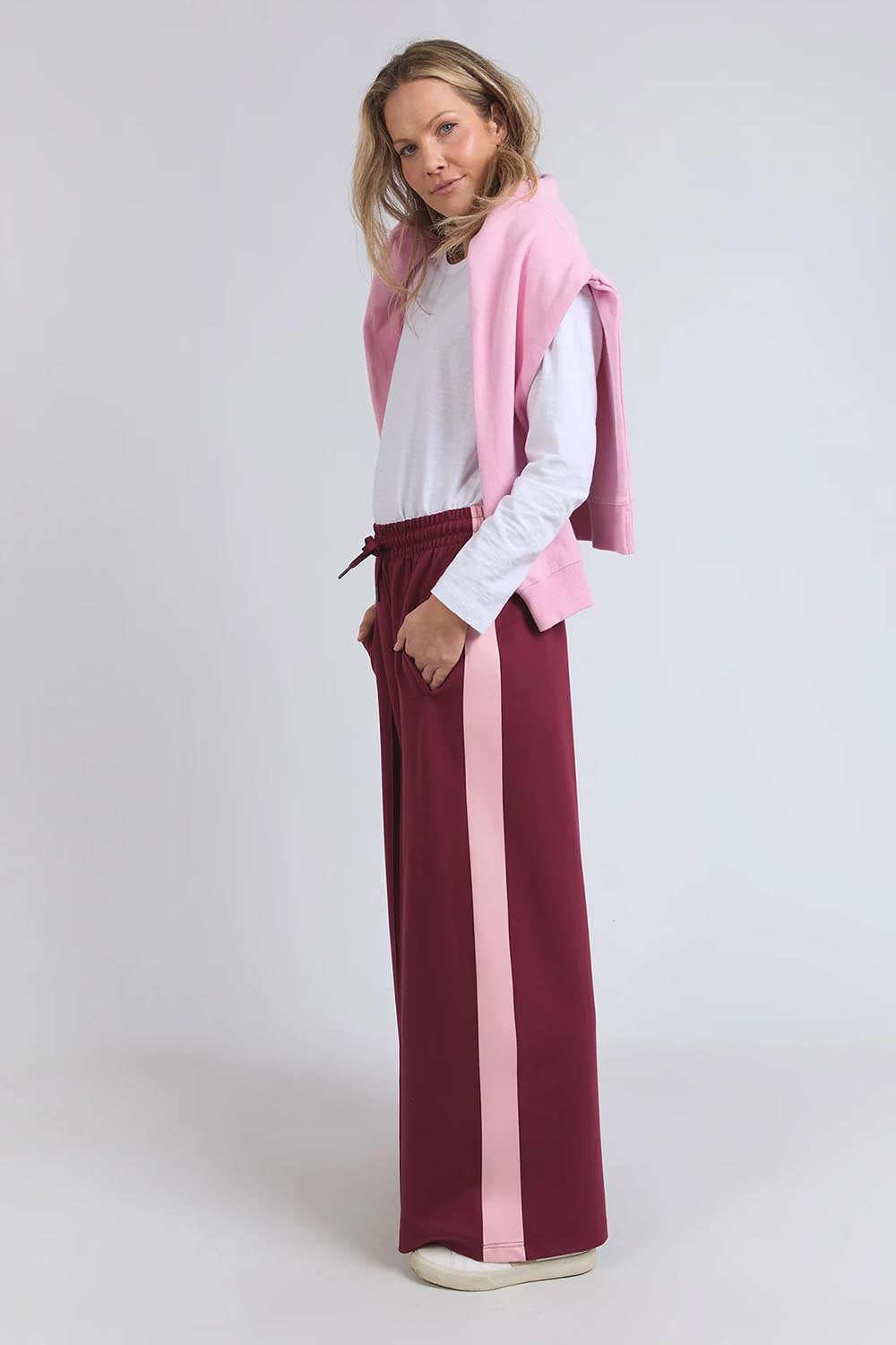 A model wearing the Carmen Wide Leg Pant in colour Merlot (Red), from the front, showing the whole outfit