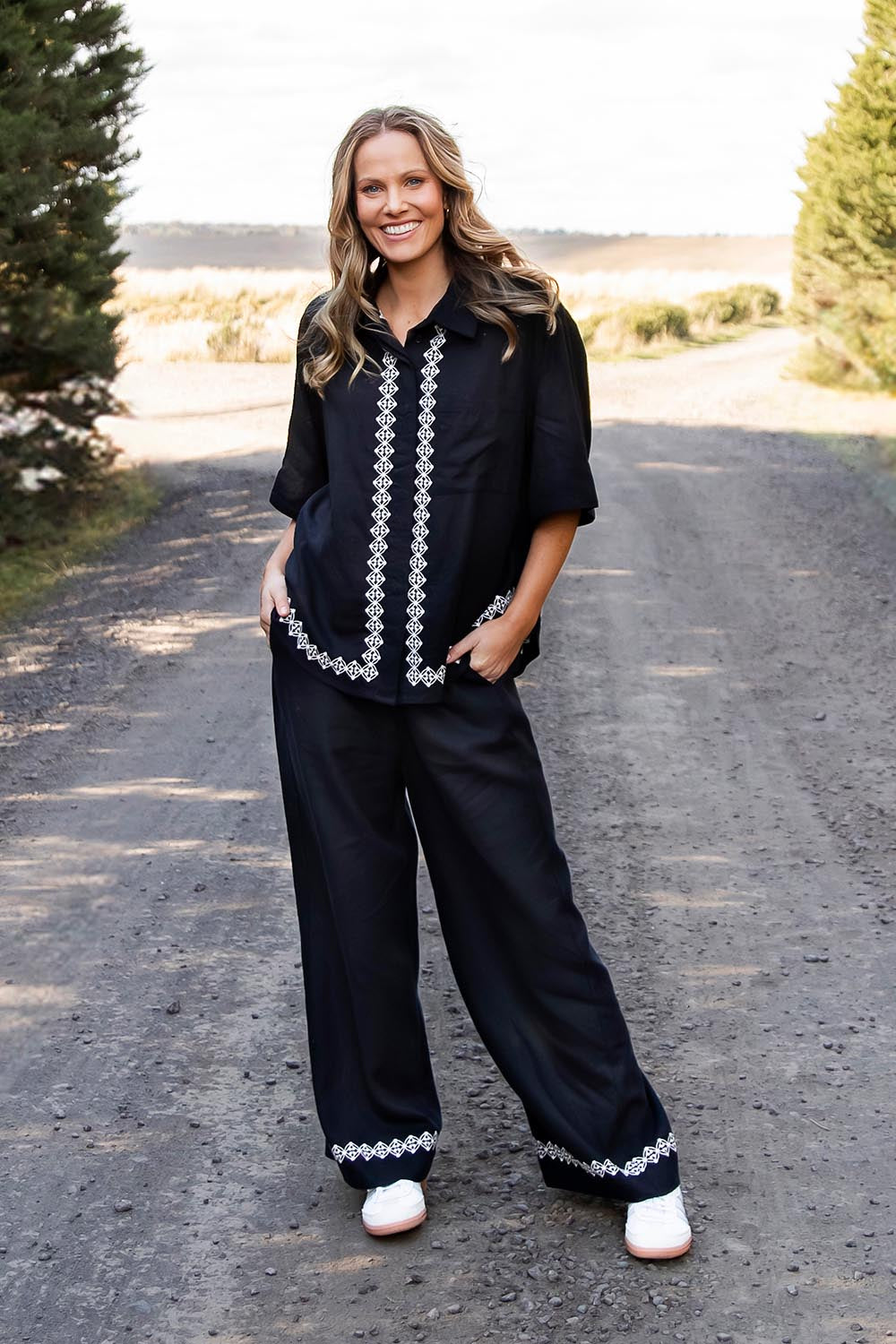 A model wearing the Nina Embroidered Pant in colour Black (Black), from the front, showing the whole outfit