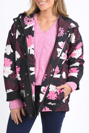 A model wearing the Hadley Floral Raincoat in colour Hadleyprin, from the front, cropped image