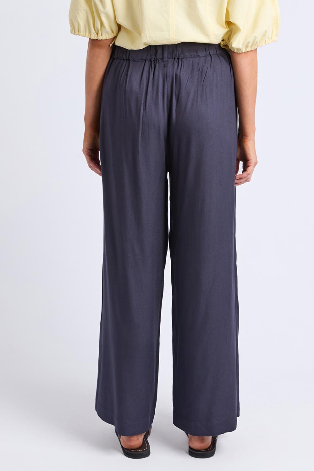 A model wearing the Georgina Pant in colour Navy (Blue), from the back