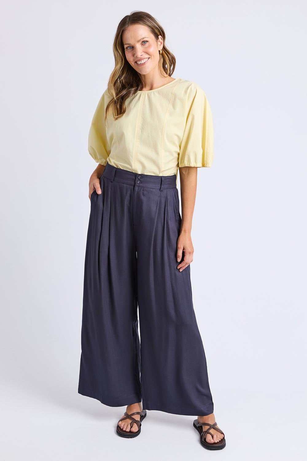 A model wearing the Georgina Pant in colour Navy (Blue), from the front, showing the whole outfit
