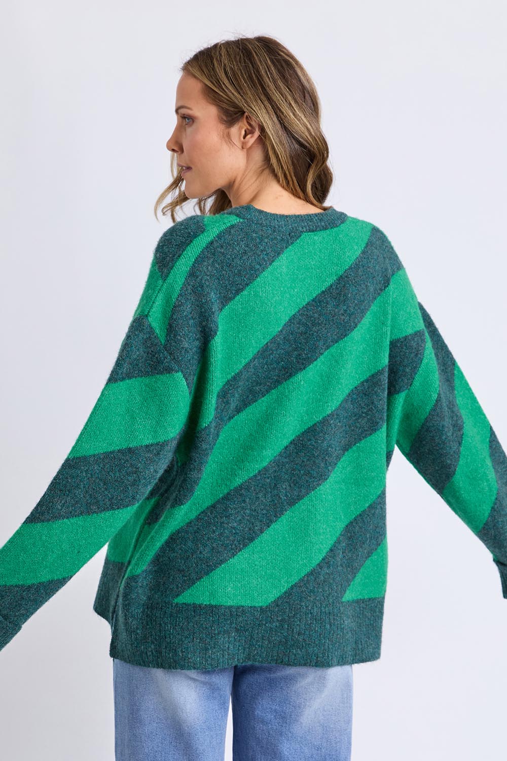 A model wearing the Sage Diagonal Stripe Knit in colour Turquoise (Green), from the back