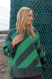 A model wearing the Sage Diagonal Stripe Knit in colour Turquoise (Green), from the front, showing the whole outfit