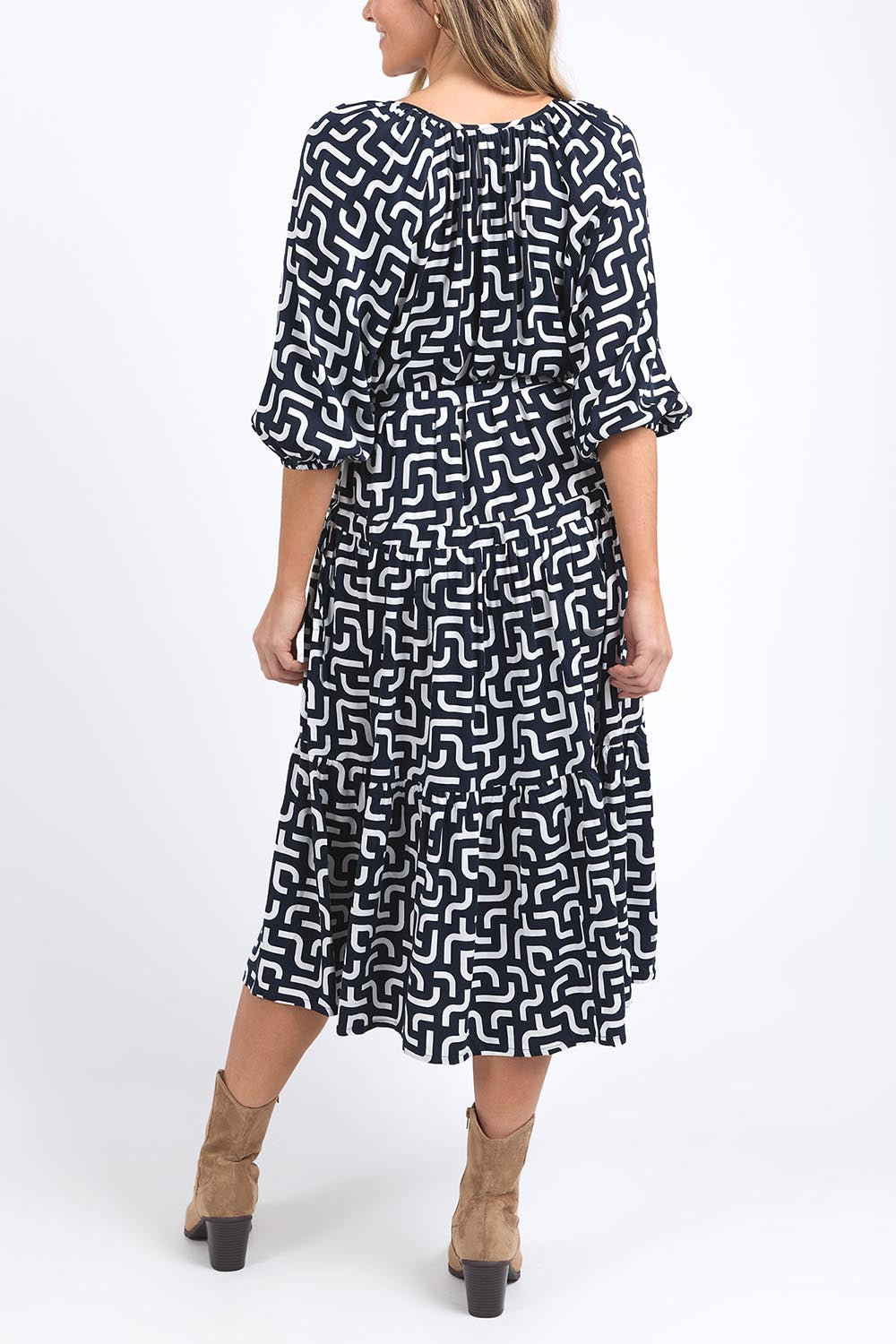 A model wearing the Gemma Geo Dress in colour Navygeo (Blue), from the back