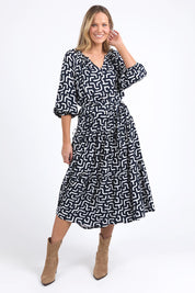 A model wearing the Gemma Geo Dress in colour Navygeo (Blue), from the front, showing the whole outfit