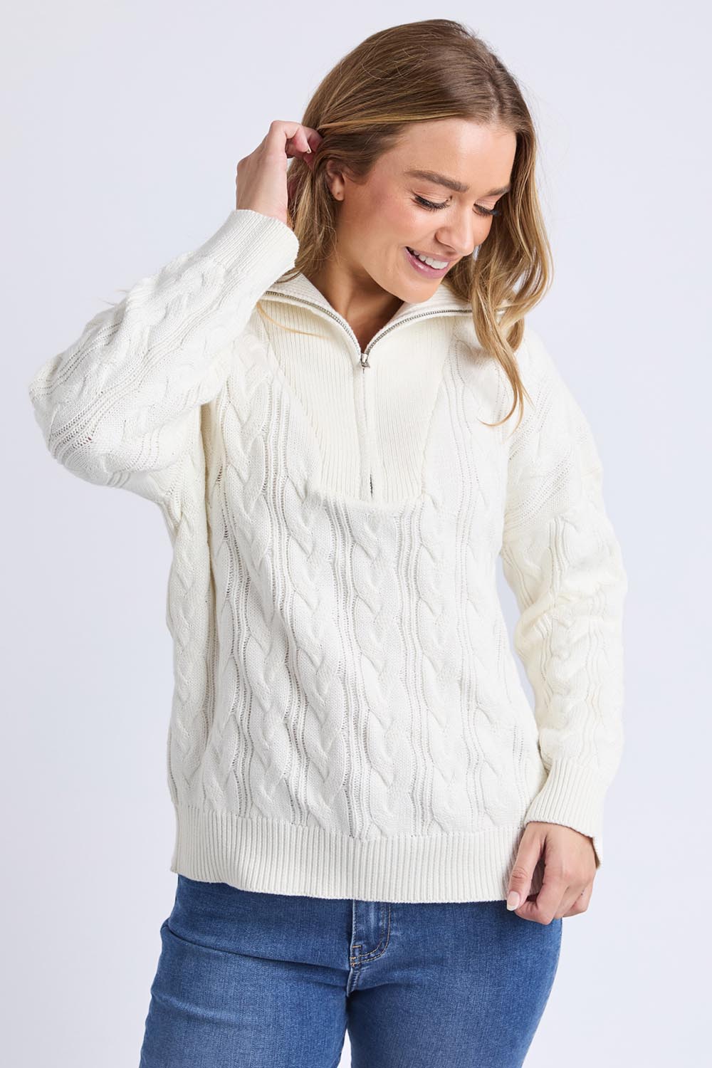 A model wearing the Zalie Zip Cotton Knit in colour Marshmello, from the front, cropped image