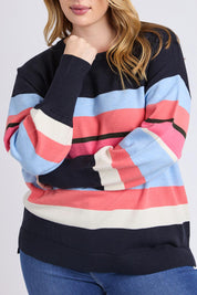 A model wearing the Lacey Stripe Knit in colour Navypink, from the front, cropped image