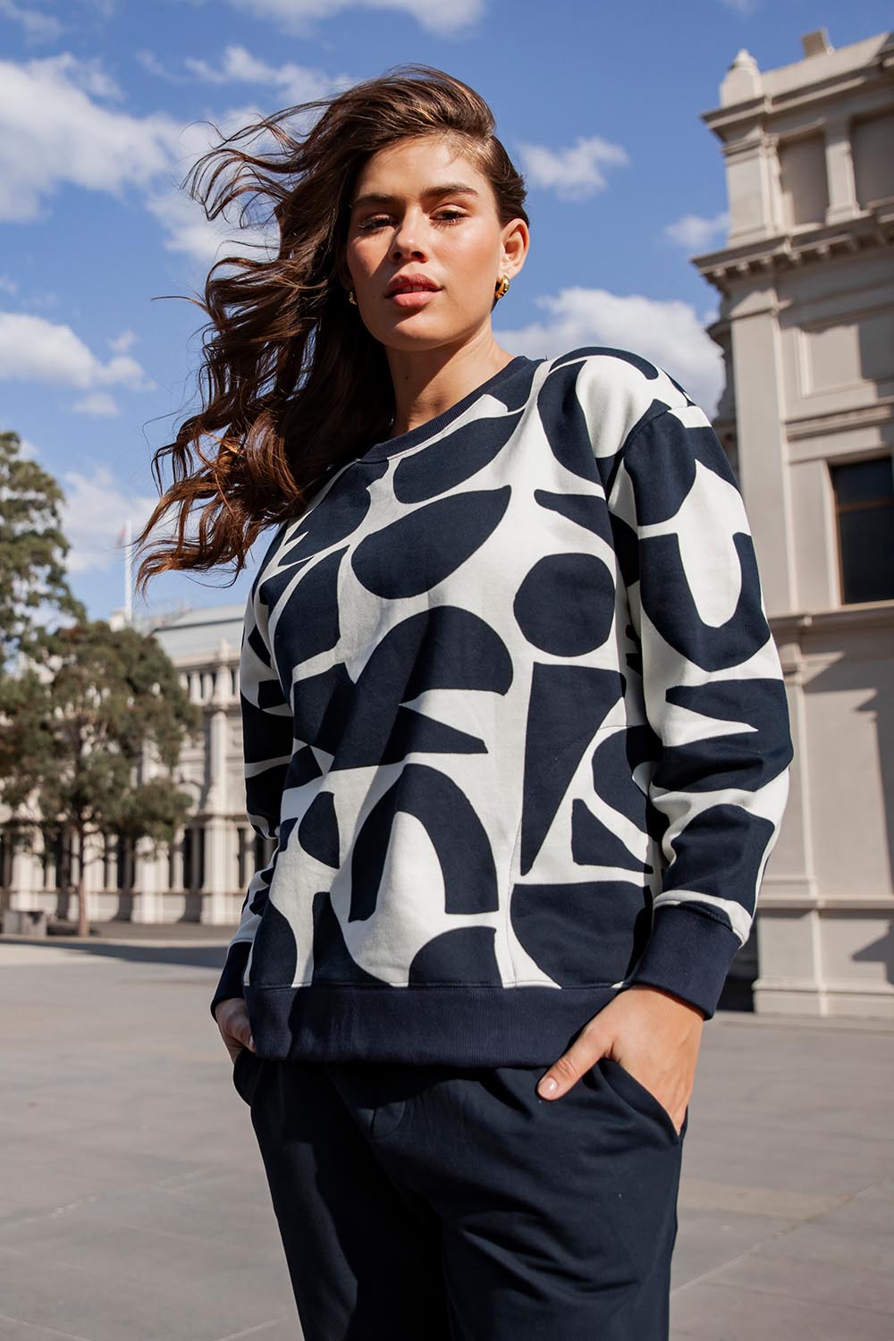 A model wearing the Mural Cotton Crew in colour Navy, from the front, showing the whole outfit