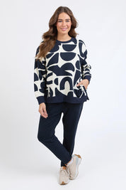 A model wearing the Mural Cotton Crew in colour Navy, from the front, showing the whole outfit