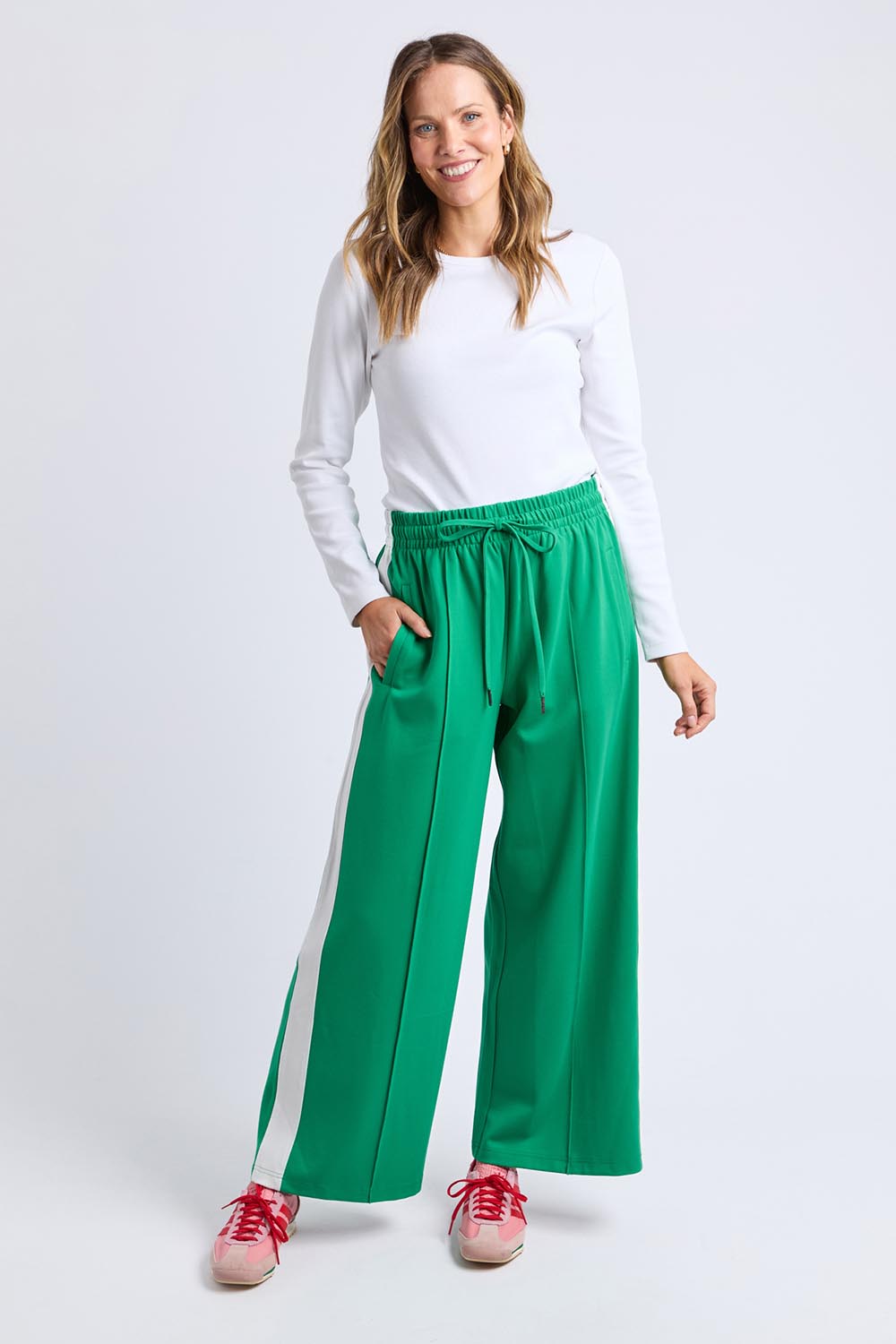 A model wearing the Carmen Wide Leg Pant in colour Pinegreen (Green), from the front, showing the whole outfit