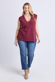 A model wearing the Bowie Cotton Blend Knit Vest in colour Plum (Red), from the front, showing the whole outfit