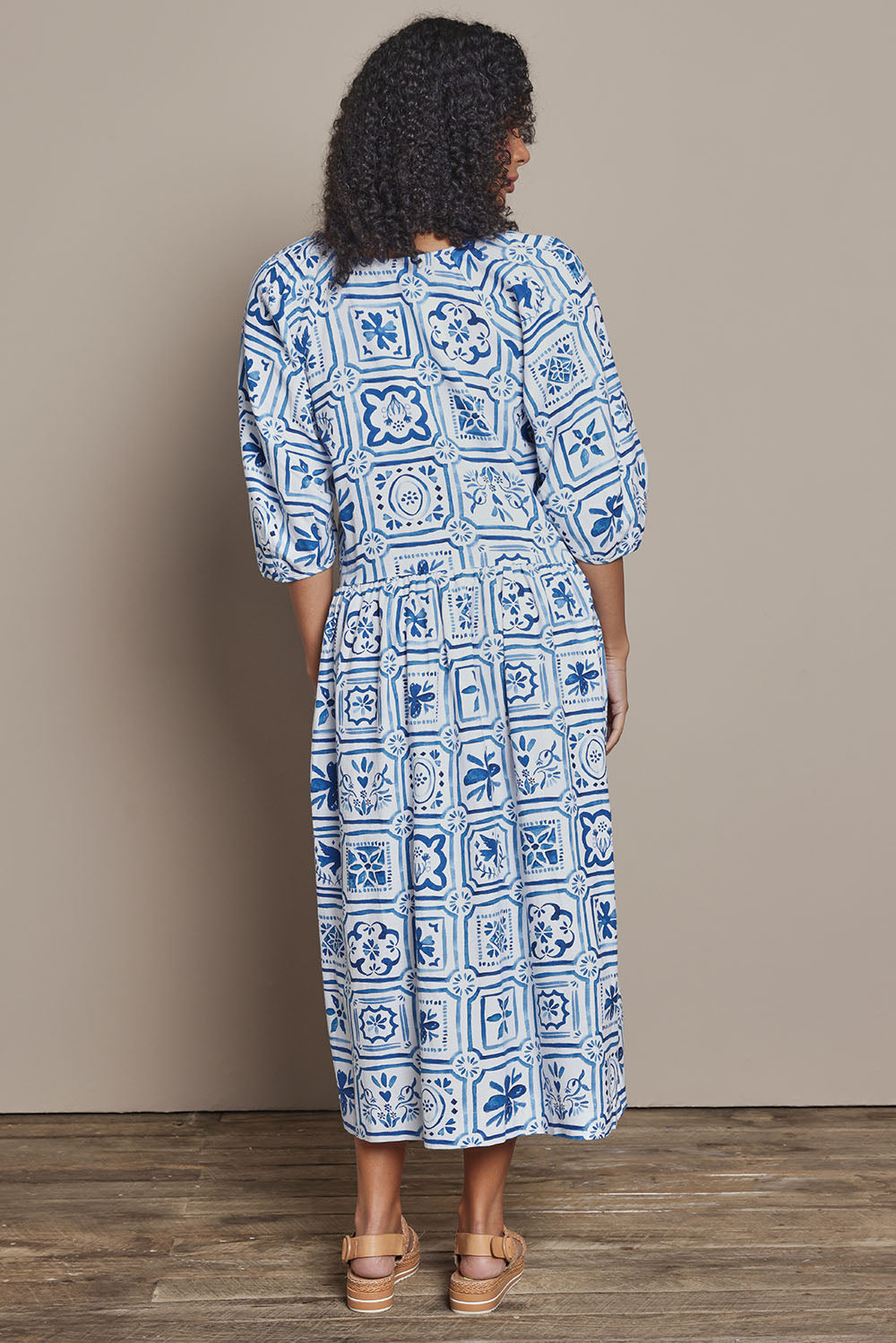 Model Ziara wearing size 10 of the Dolce Tile Cotton Blend Midi Dress in colour Oceantile (Blue), from the back