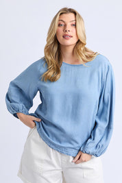 A model wearing the Della Lyocell Chambray Top in colour Midblue (Blue), from the front, cropped image