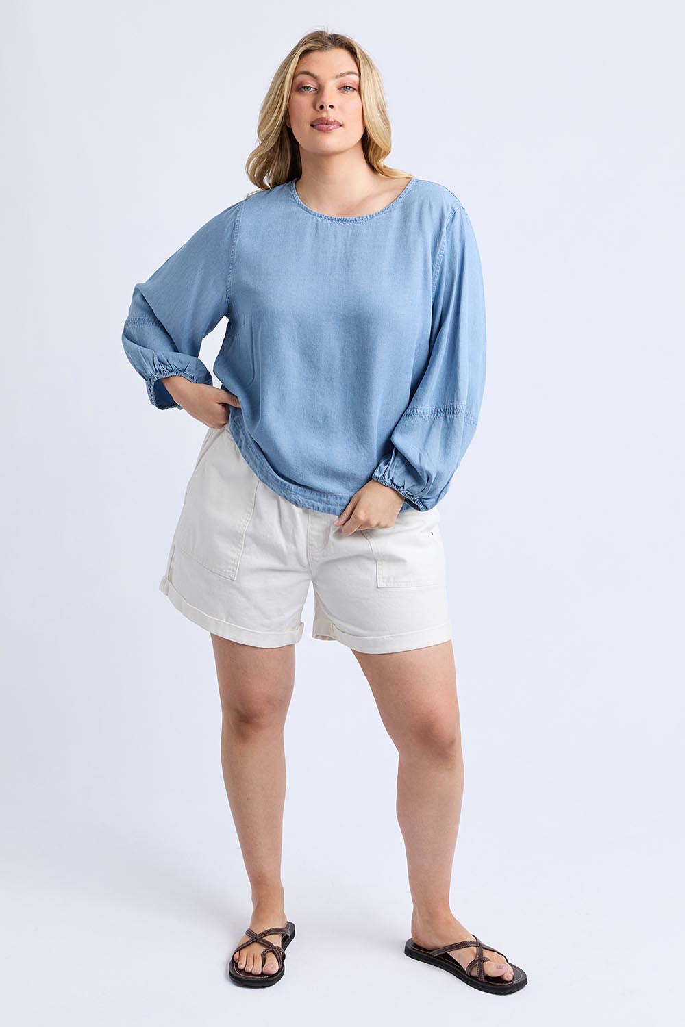 A model wearing the Della Lyocell Chambray Top in colour Midblue (Blue), from the front, showing the whole outfit
