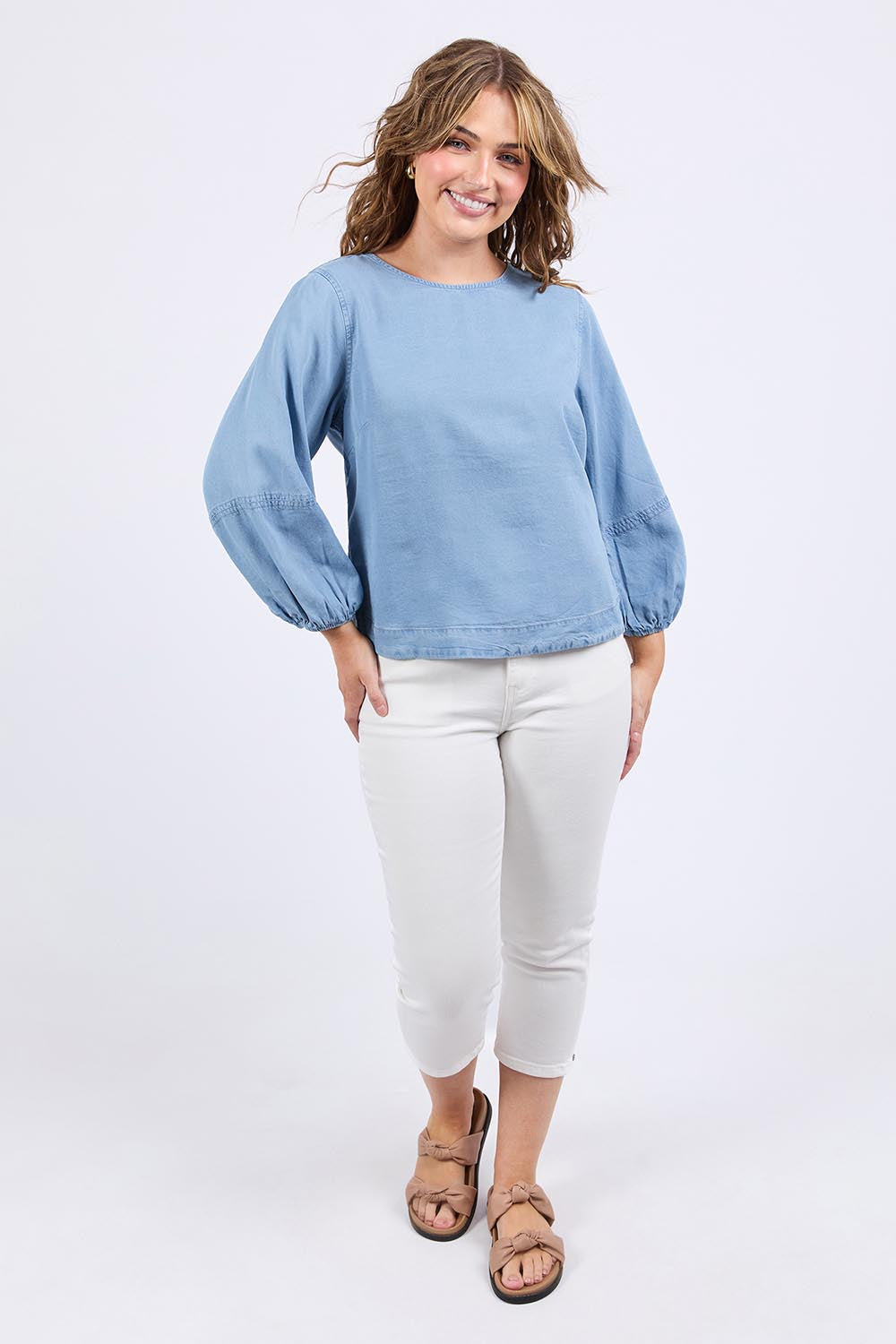 A model wearing the Della Lyocell Chambray Top in colour Midblue (Blue), from the front, showing the whole outfit