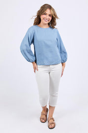 A model wearing the Della Lyocell Chambray Top in colour Midblue (Blue), from the front, showing the whole outfit