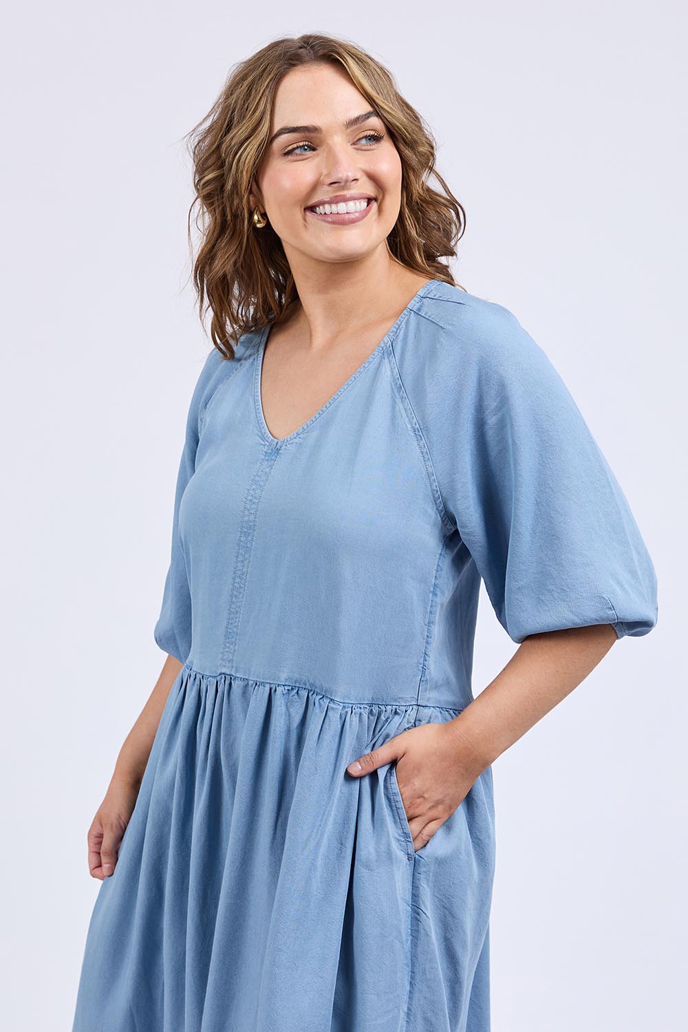 A model wearing the Sawyer Chambray Dress in colour Midblue (Blue), from the front, cropped image