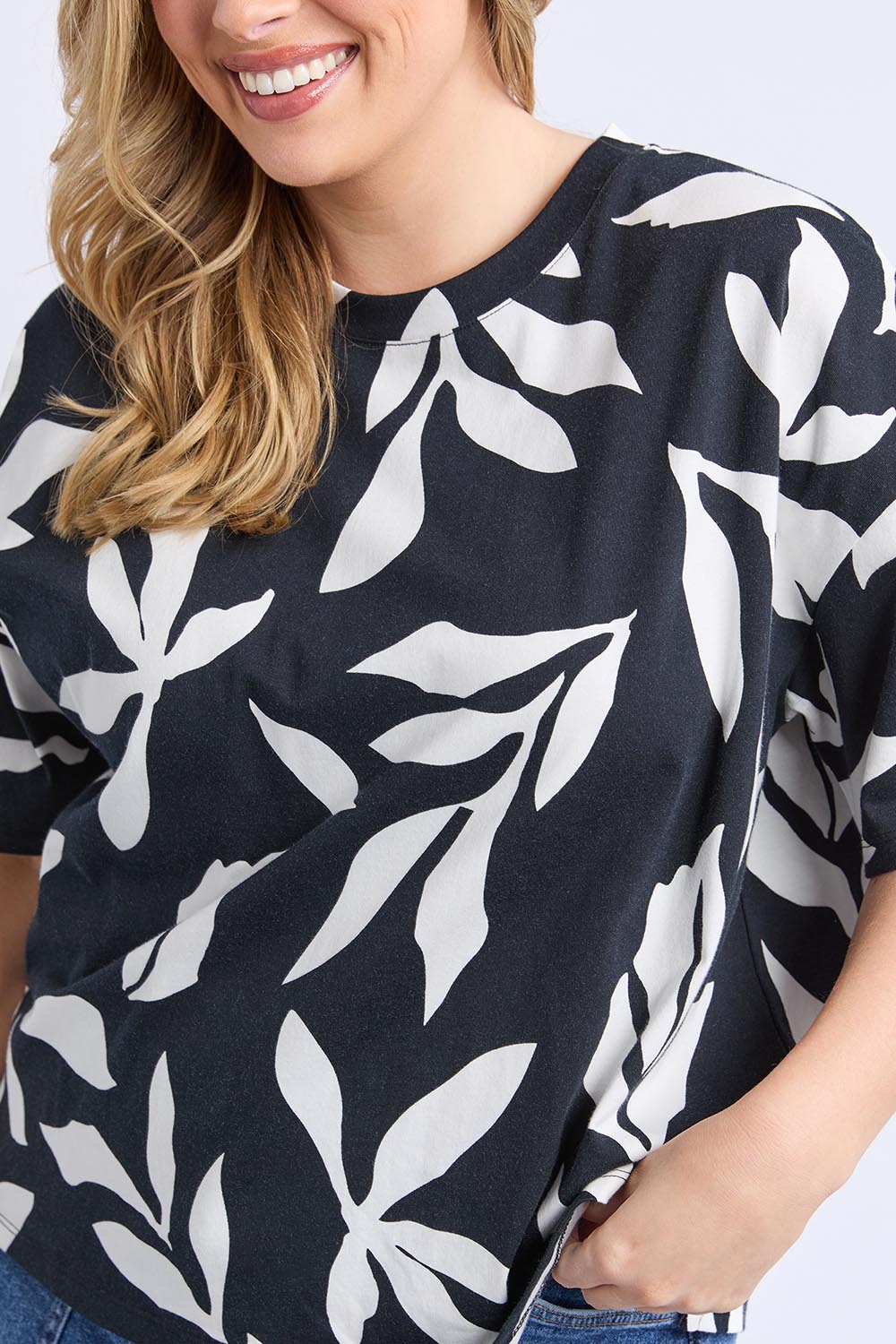 A model wearing the Mimosa Cotton Tee in colour Blackprint (Black), from the front, cropped image