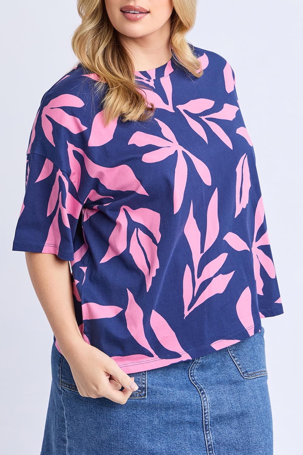 A model wearing the Mimosa Cotton Tee in colour Bluedepths, from the front, cropped image