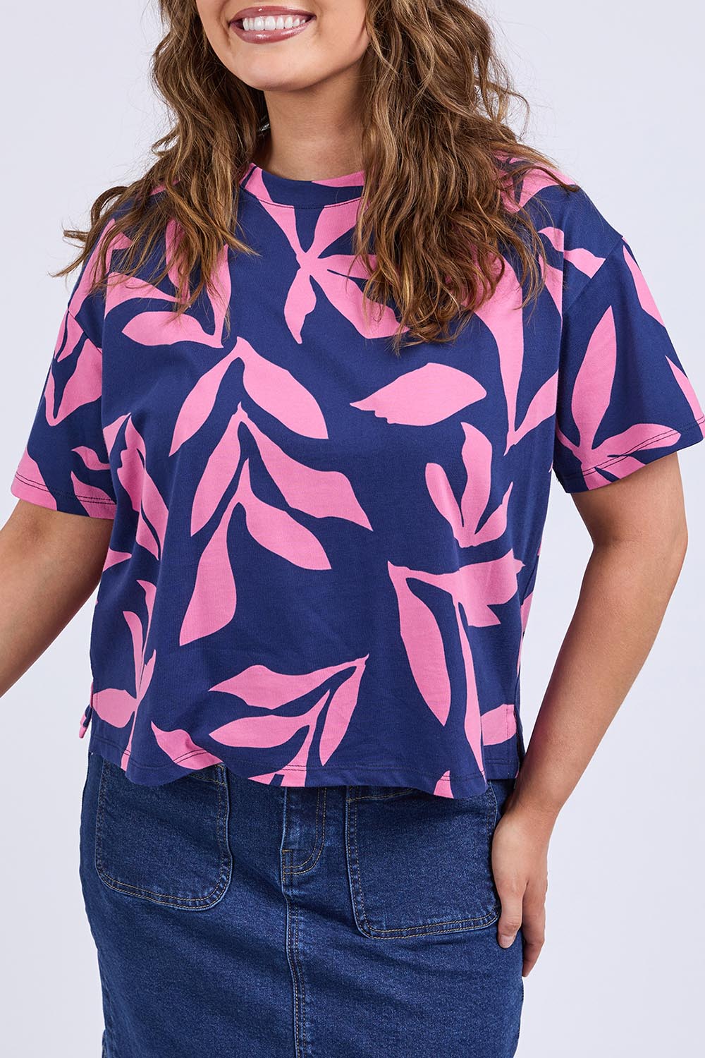 A model wearing the Mimosa Cotton Tee in colour Bluedepths, from the front, cropped image