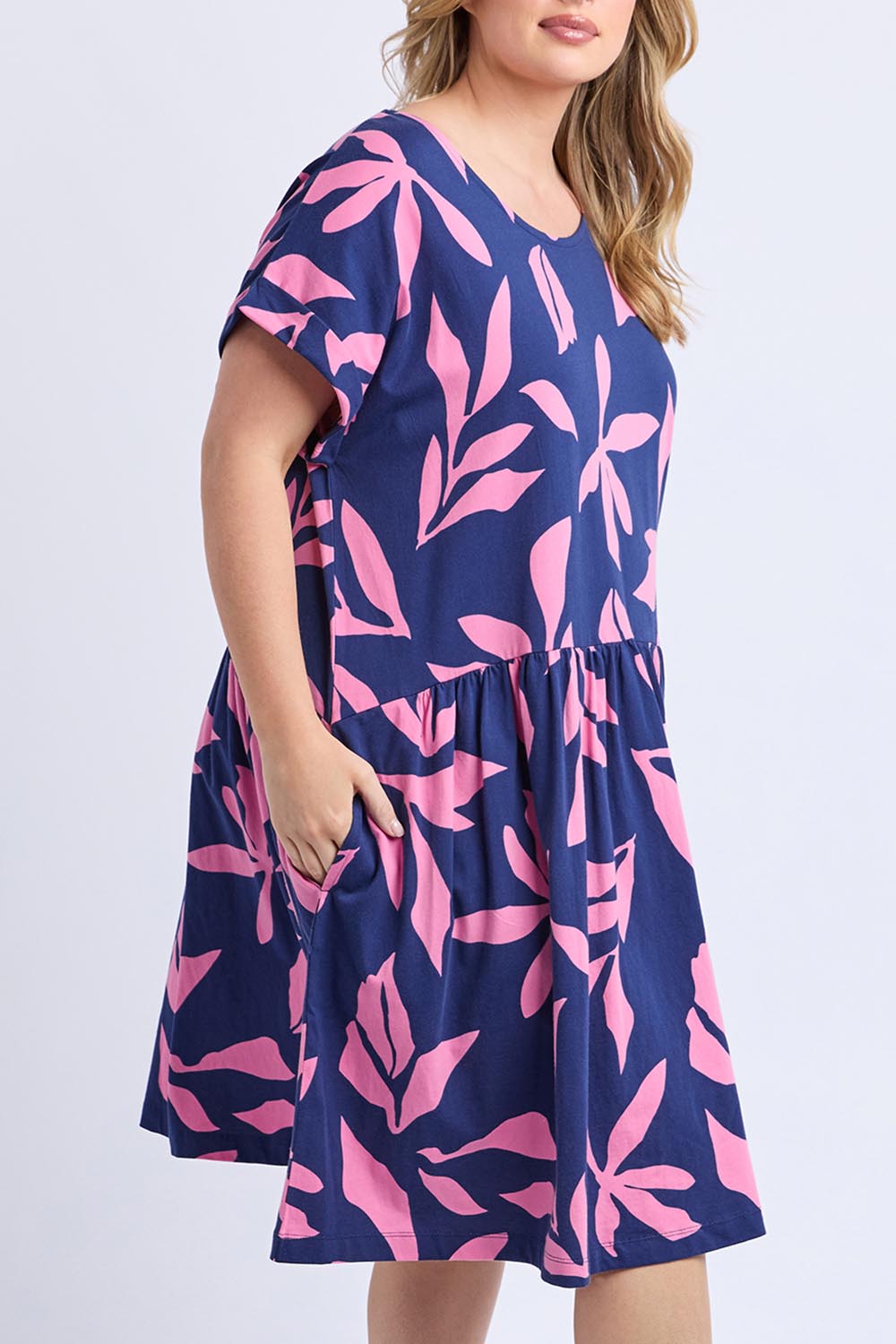 A model wearing the Mimosa Cotton Dress in colour Bluedepths, from the front, cropped image