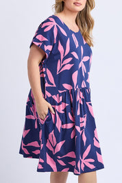 A model wearing the Mimosa Cotton Dress in colour Bluedepths, from the front, cropped image