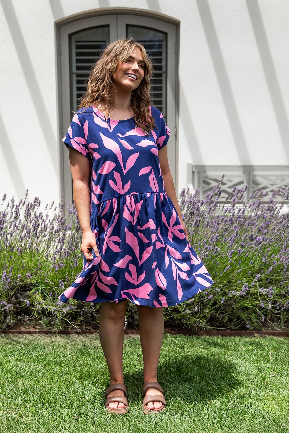 A model wearing the Mimosa Cotton Dress in colour Bluedepths, from the front, showing the whole outfit