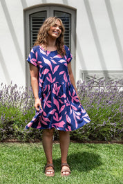 A model wearing the Mimosa Cotton Dress in colour Bluedepths, from the front, showing the whole outfit
