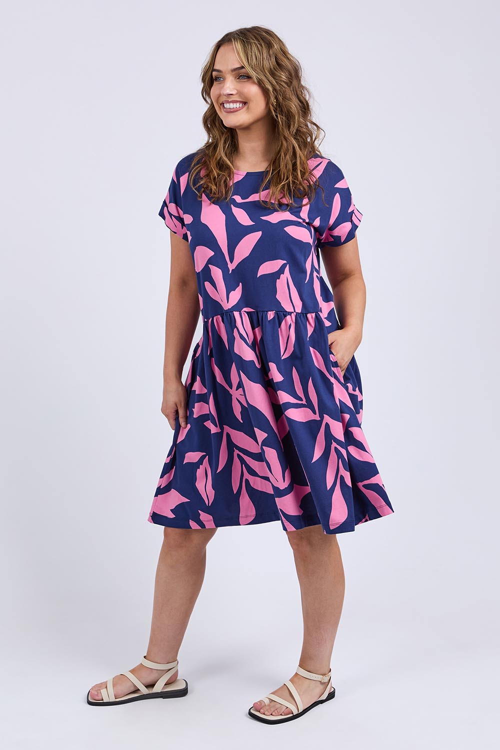 A model wearing the Mimosa Cotton Dress in colour Bluedepths, from the front, showing the whole outfit