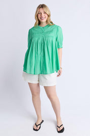 A model wearing the Monty Cotton Short Sleeve Shirt in colour Gumdrop (Green), from the front, showing the whole outfit