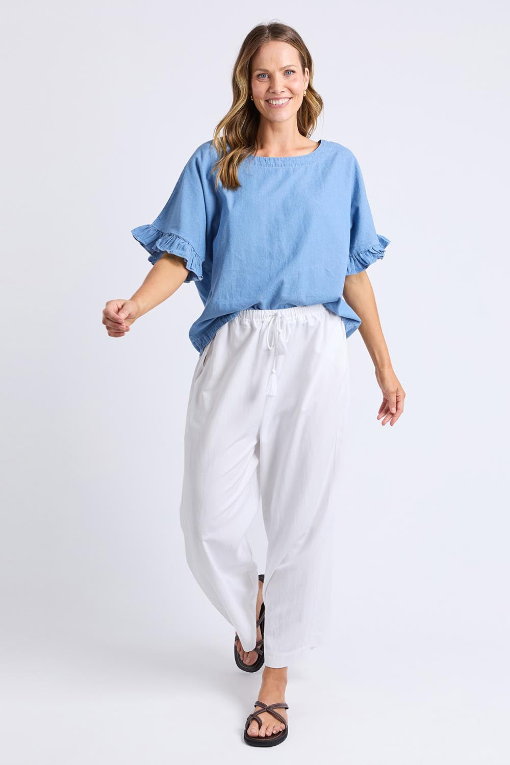 A model wearing the Tilda Chambray Shirt in colour Lightblue (Blue), from the front, showing the whole outfit